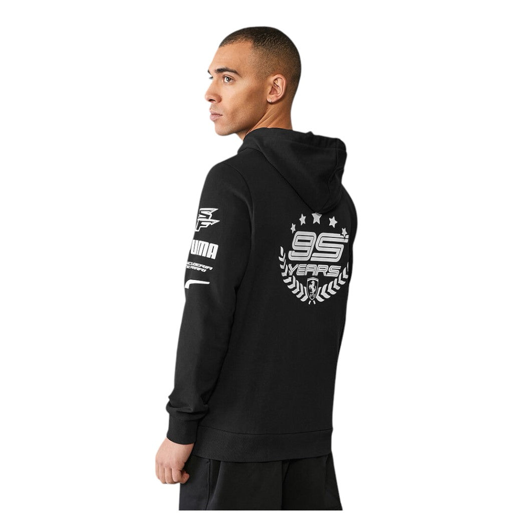 Person wearing a black hoodie with white branding on the back, standing against a white background