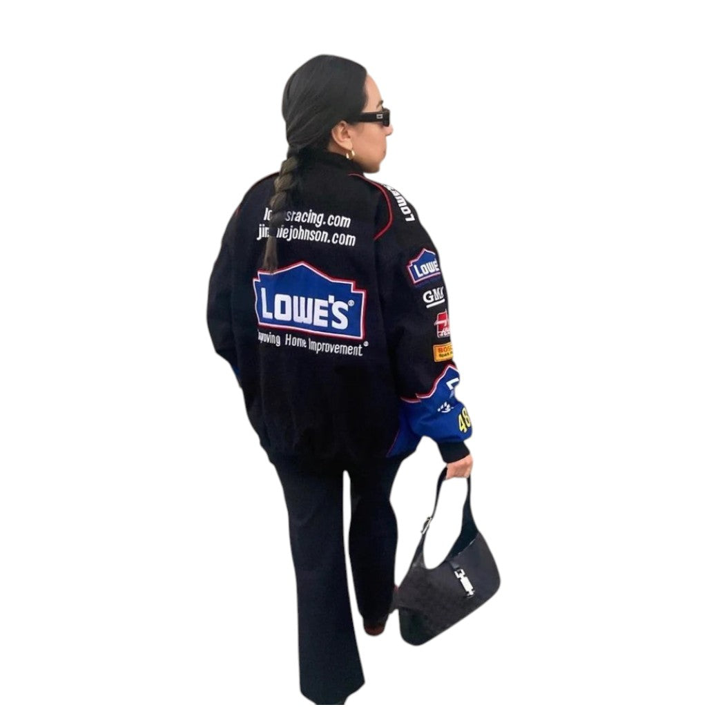 Person wearing a black racing suit with sponsor logos on a white background