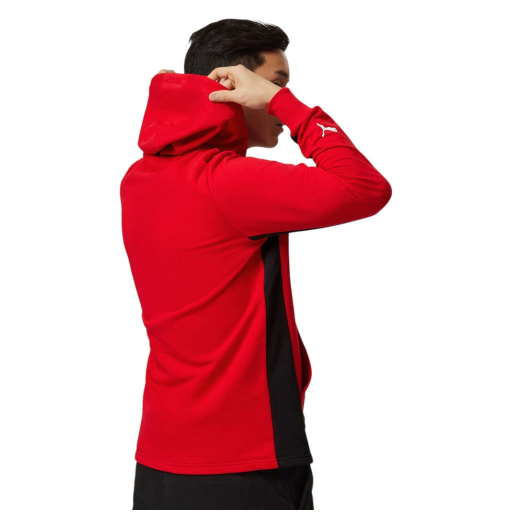 Person wearing a red and black hoodie with a brand logo on a white background
