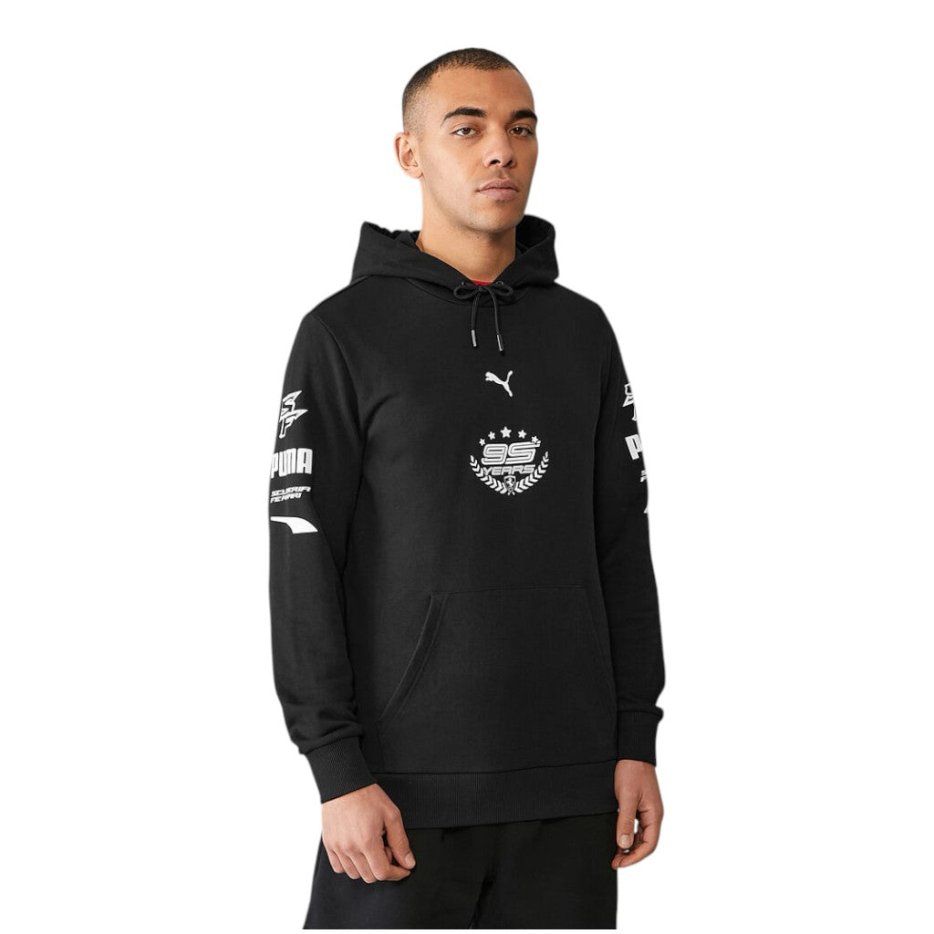 Man wearing a black hoodie with brand logos on a white background