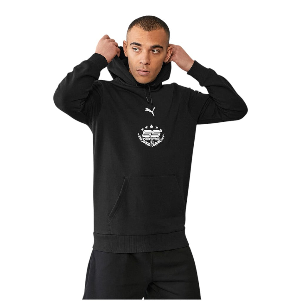 Person wearing a black hoodie with a logo on a white background