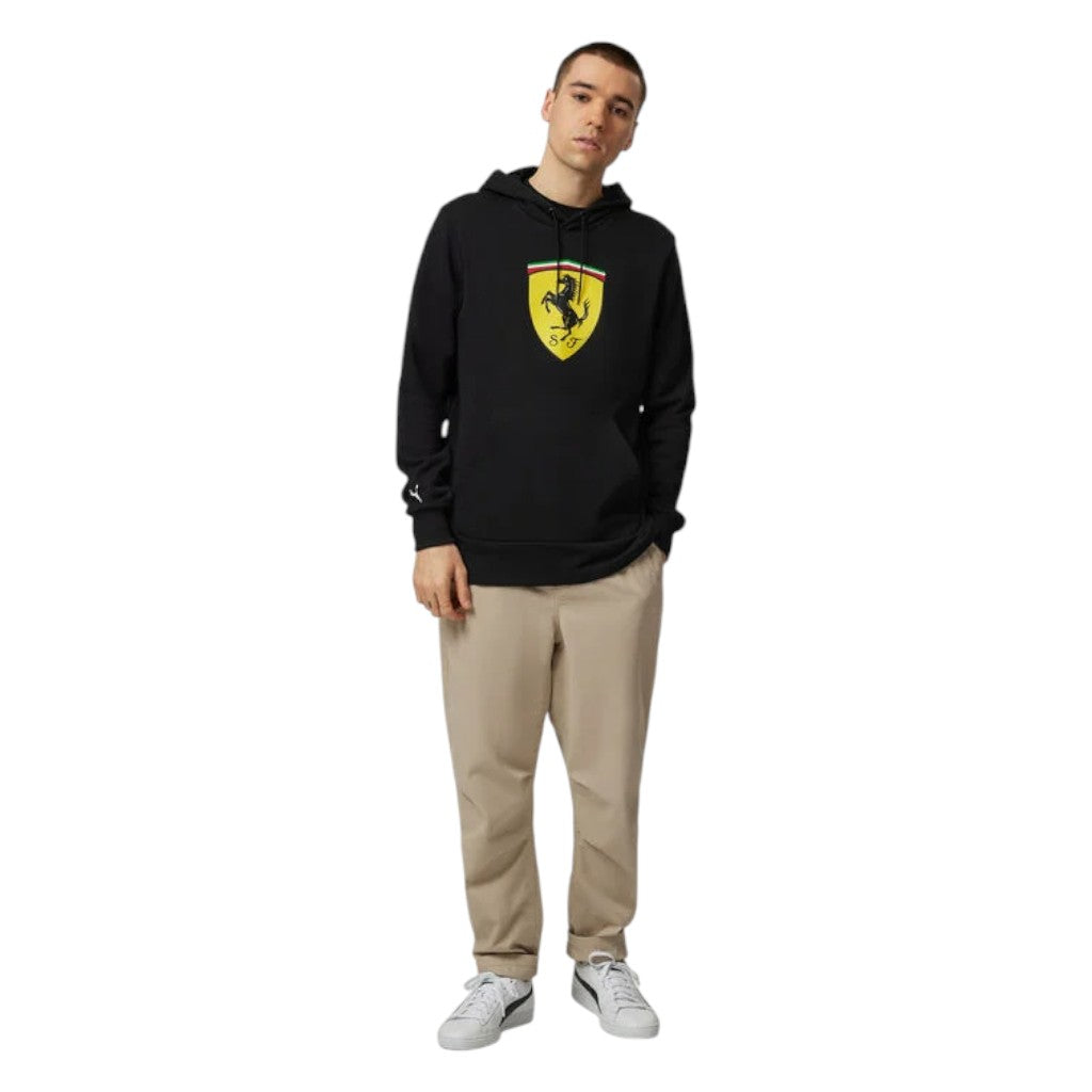 Person wearing a black hoodie with a yellow logo on a white background