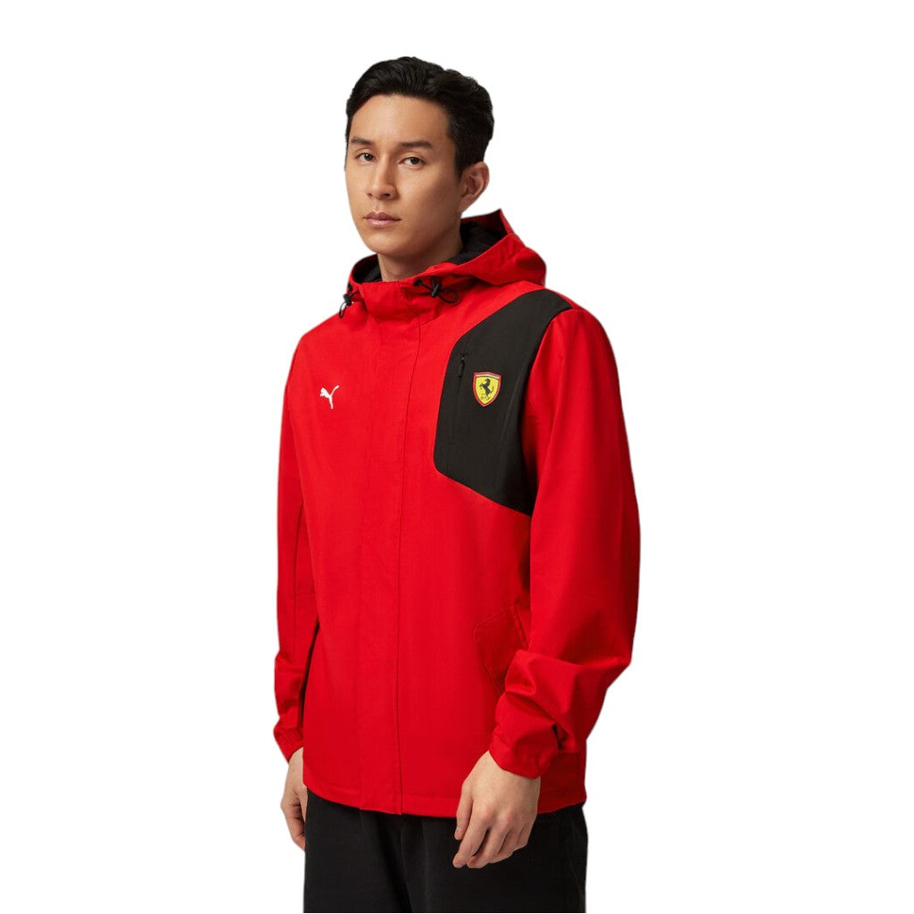 Person wearing a red and black jacket with a logo on a white background