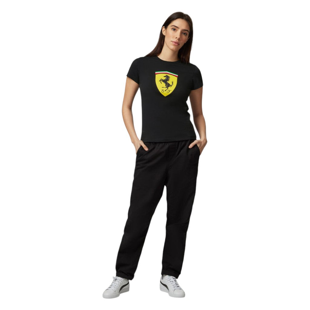 Woman wearing a black t-shirt with a yellow logo and black pants on a white background