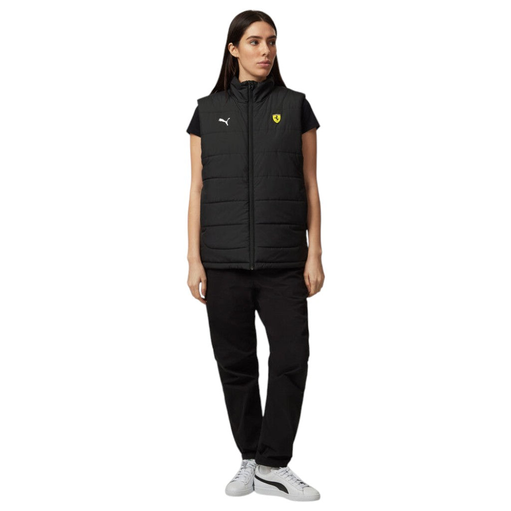 Woman wearing a black vest with a logo and matching pants on a white background