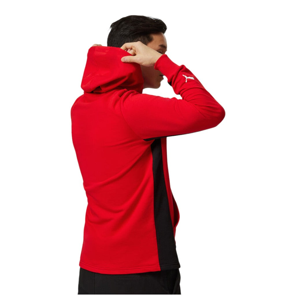 Person wearing a red and black hoodie with a brand logo on a white background