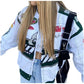 Person wearing a white racing jacket with various logos and a black bag over one shoulder.