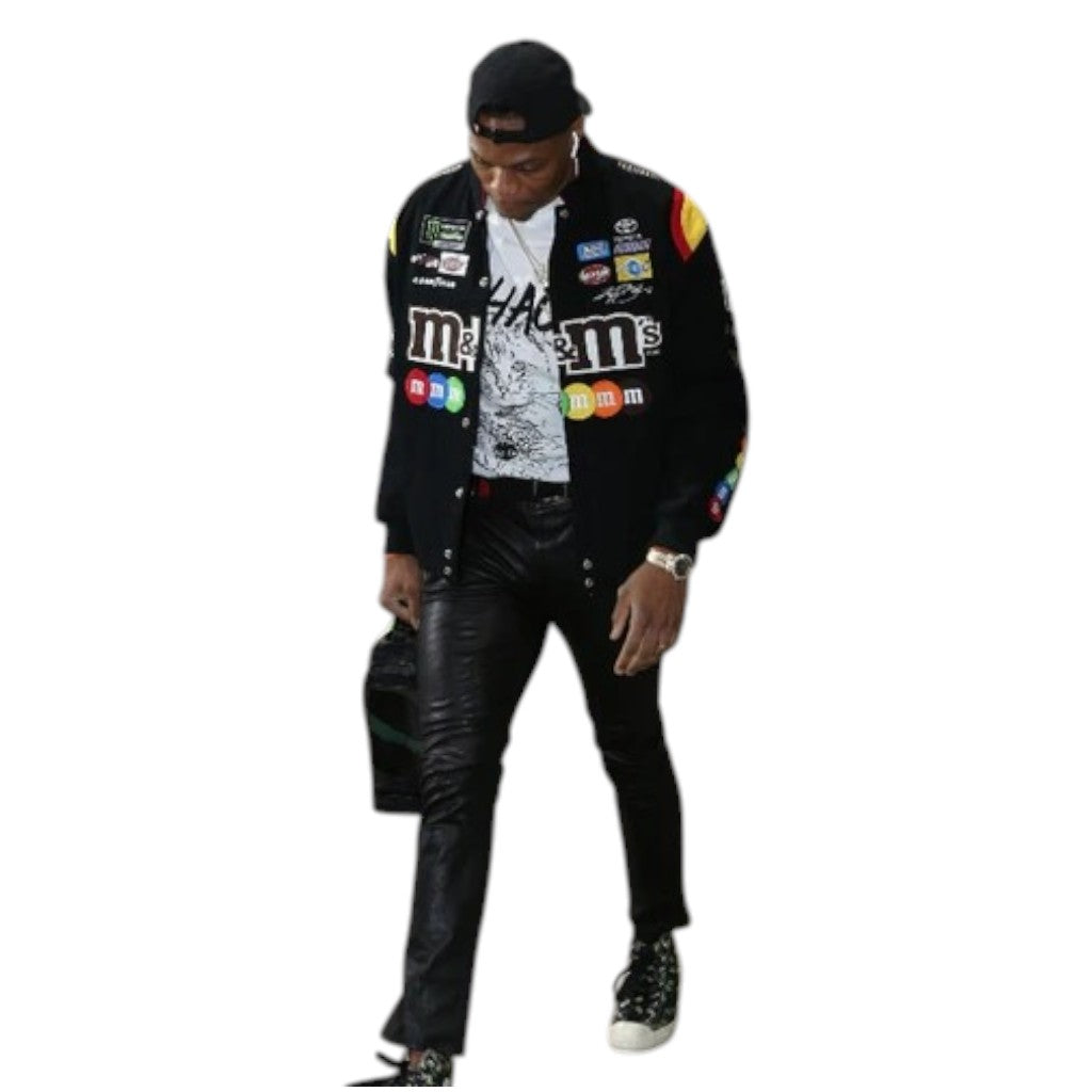 Person wearing a black jacket with various logos on a white background