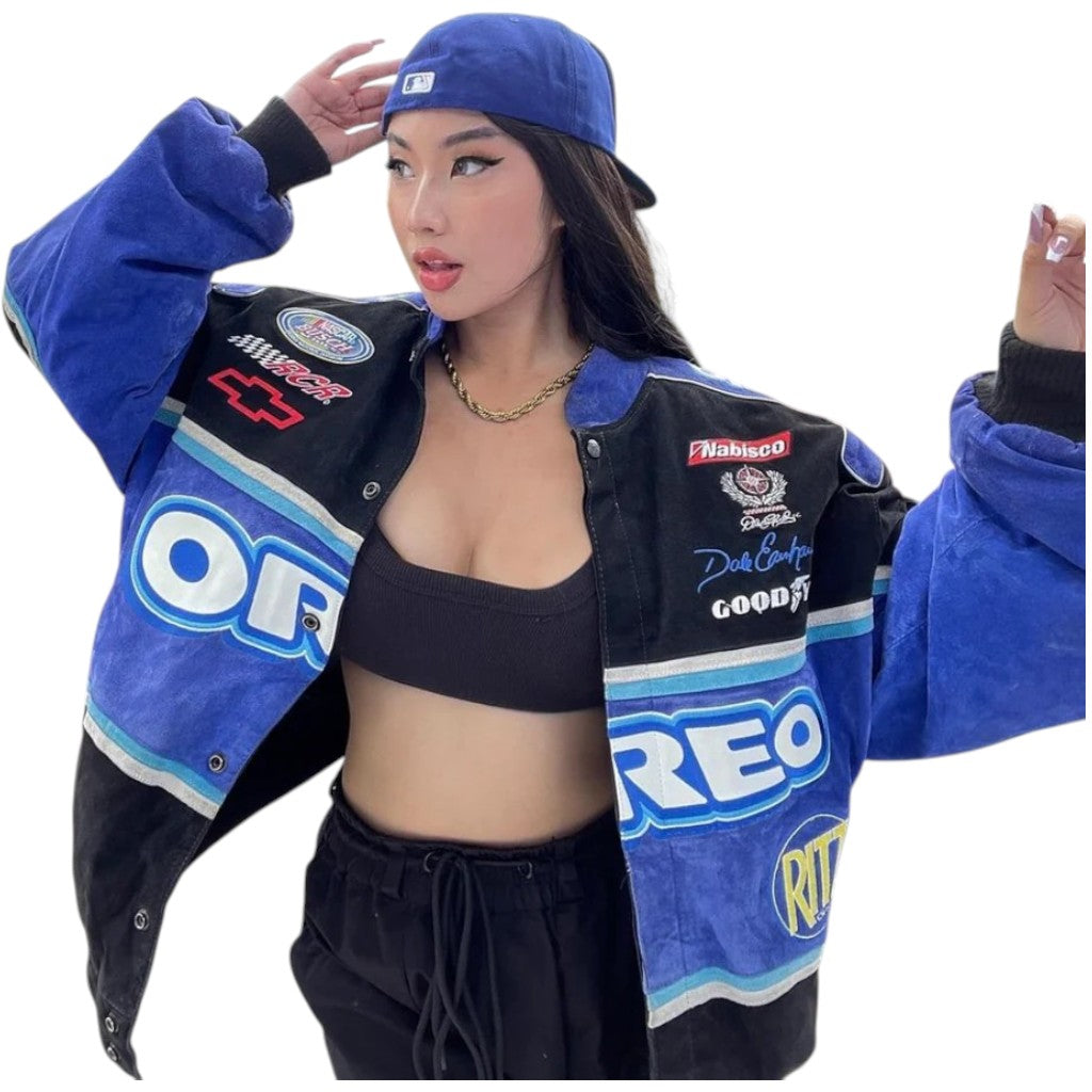 Woman wearing a blue racing jacket with various sponsor logos on a white background